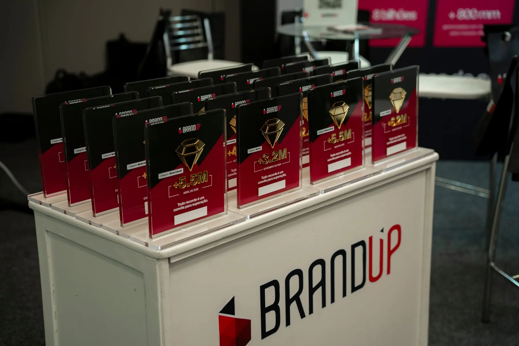 Mesa da BRANDUP com dezenas de placas comemorativas de recordes de faturamento de clientes de e-commerce